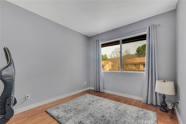 interior space featuring baseboards and wood finished floors