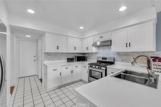 kitchen with under cabinet range hood, a sink, white cabinetry, light countertops, and stainless steel range with gas stovetop