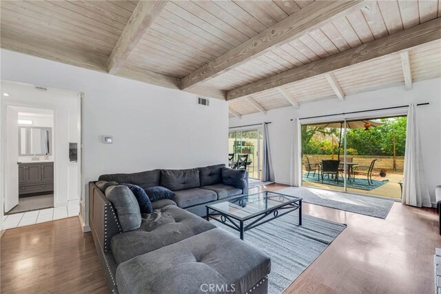 living area featuring wood ceiling, visible vents, wood finished floors, and beamed ceiling