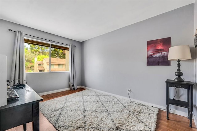 interior space with baseboards and wood finished floors