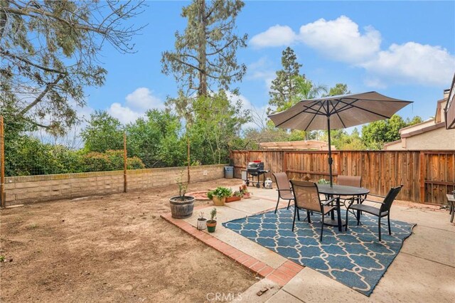 view of patio / terrace featuring a fenced backyard, area for grilling, and outdoor dining space