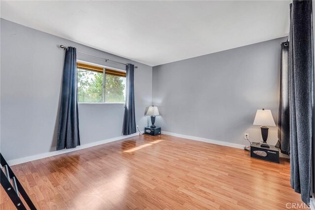 spare room with light wood-type flooring and baseboards