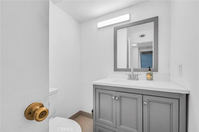 bathroom with visible vents, vanity, and toilet