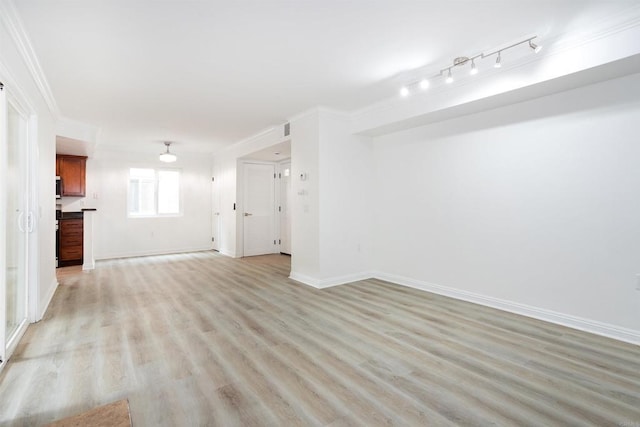 unfurnished living room featuring baseboards, crown molding, and light wood finished floors