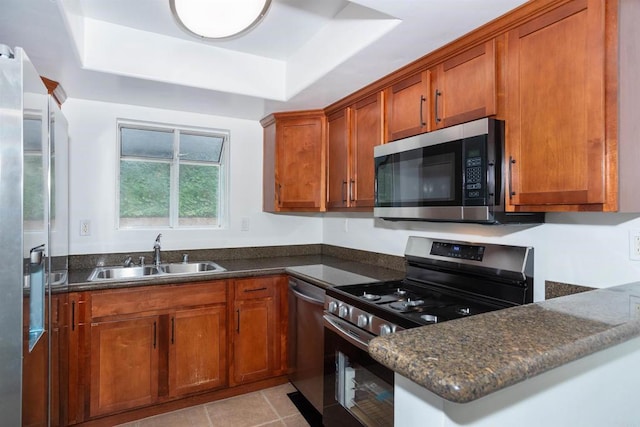 800 Sea Cliff Way Unit 801, Oceanside, CA 92056 - kitchen with stainless steel appliances, a raised ceiling, brown cabinets, and dark stone counters