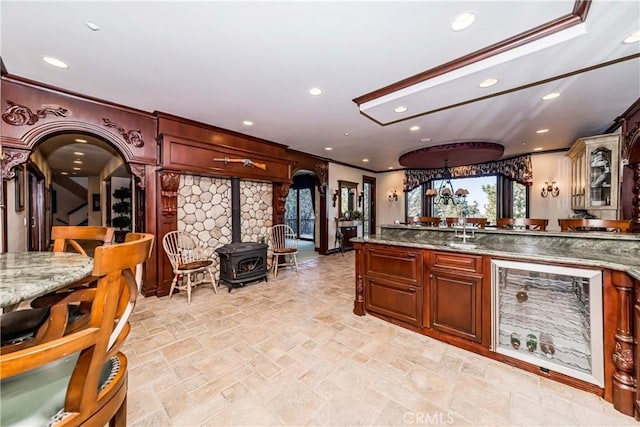 293 Fairway Dr, Lake Arrowhead, CA 92352 - kitchen featuring ornamental molding, recessed lighting, arched walkways, a sink, and a wood stove
