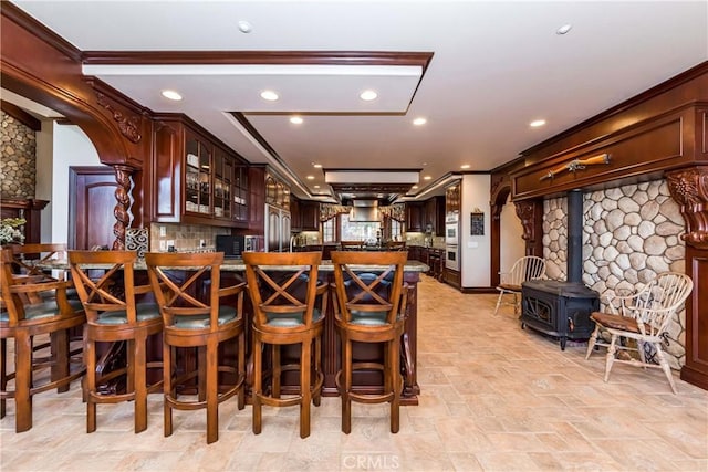 293 Fairway Dr, Lake Arrowhead, CA 92352 - kitchen with decorative backsplash, stone finish floor, a peninsula, dark countertops, and glass insert cabinets