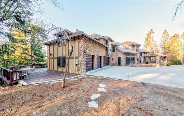 293 Fairway Dr, Lake Arrowhead, CA 92352 - view of side of property featuring concrete driveway, stucco siding, an attached garage, stone siding, and a chimney