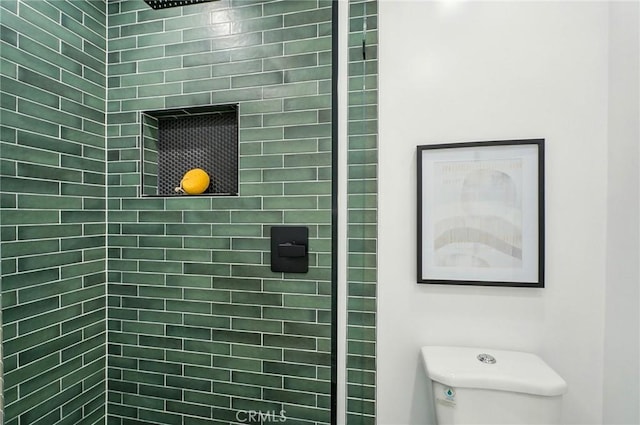 bathroom featuring toilet and tiled shower