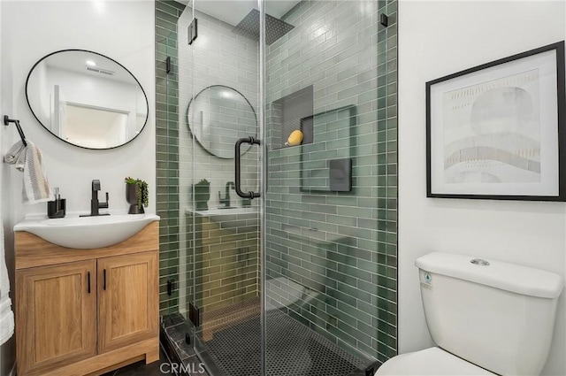 bathroom with visible vents, vanity, a shower stall, and toilet