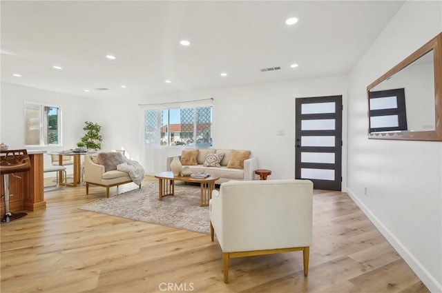 living area with light wood-type flooring, baseboards, visible vents, and recessed lighting