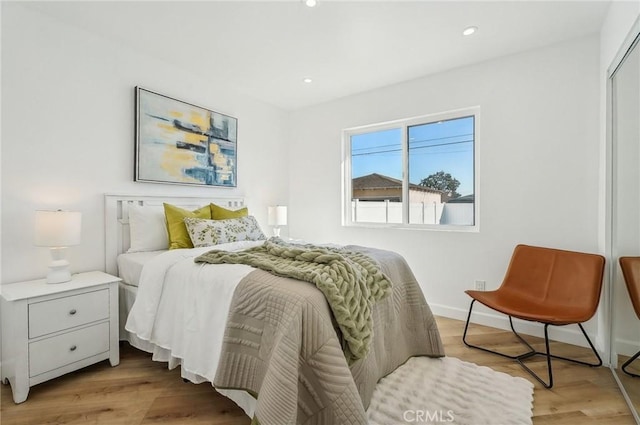 bedroom featuring baseboards, light wood-type flooring, and recessed lighting