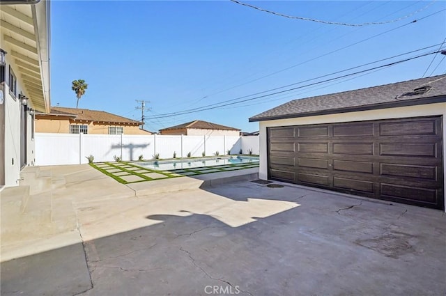 detached garage with a swimming pool and fence