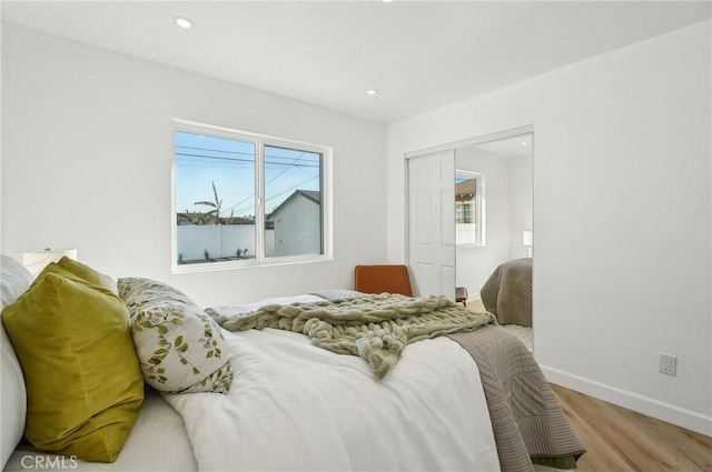 bedroom featuring recessed lighting, a closet, baseboards, and wood finished floors