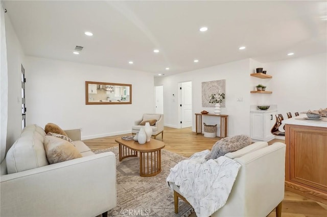 living room with recessed lighting, baseboards, visible vents, and light wood finished floors