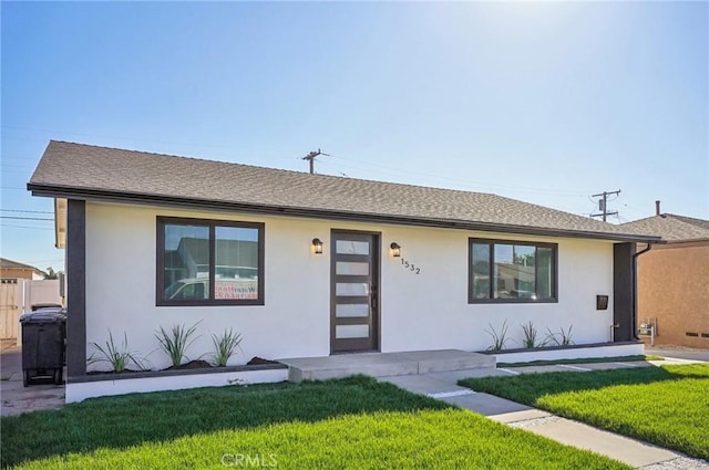 ranch-style home featuring a shingled roof, a front lawn, and stucco siding