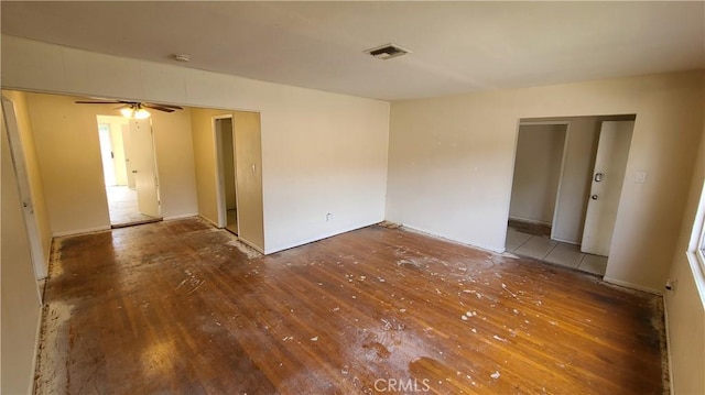 spare room featuring visible vents, a ceiling fan, and wood finished floors