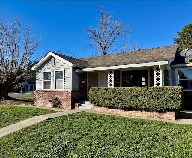 single story home with brick siding and a front yard