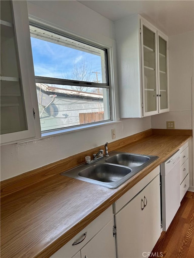 kitchen featuring glass insert cabinets, white cabinetry, dishwasher, and a sink