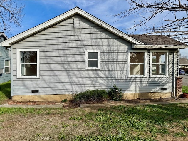 view of side of property with a yard and crawl space