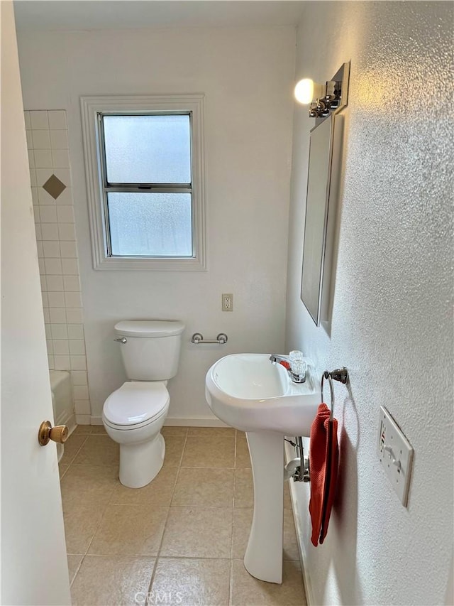 full bath featuring toilet, tile patterned flooring, and baseboards