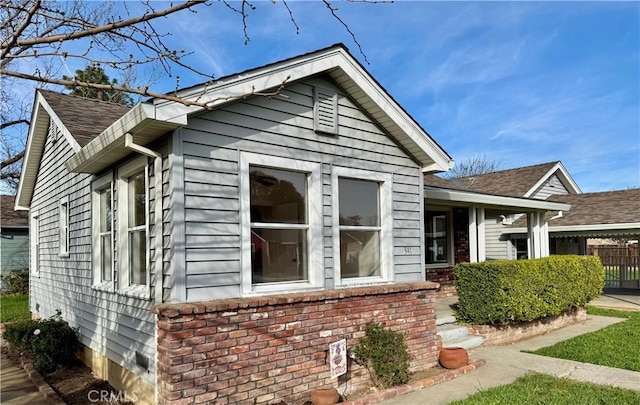 view of property exterior with brick siding and fence