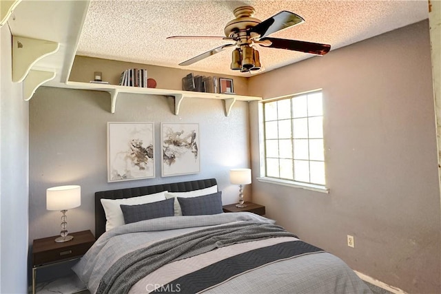 bedroom with ceiling fan and a textured ceiling