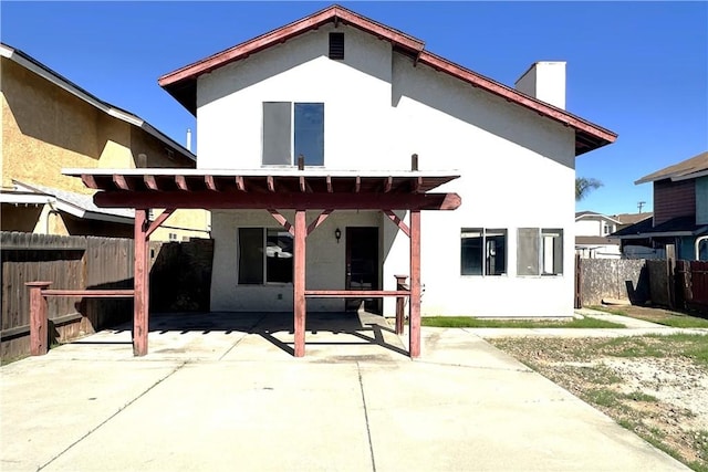 back of property with a patio, fence, and stucco siding