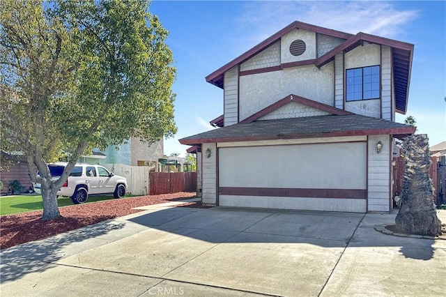 view of front of property with a garage, driveway, a shingled roof, and fence