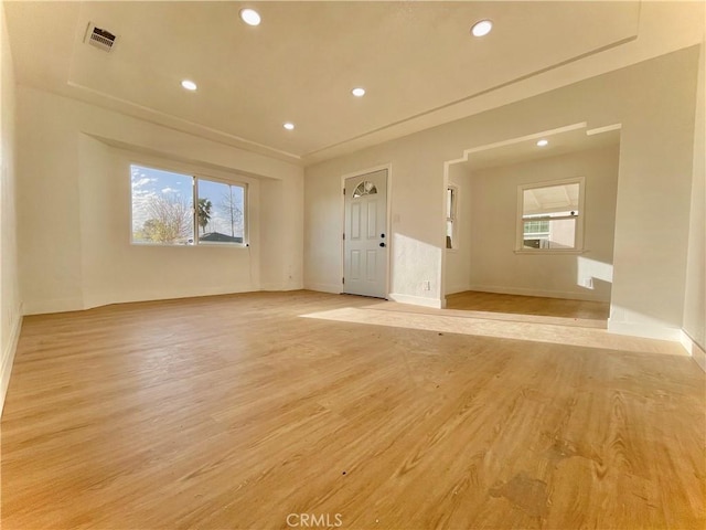 spare room with light wood finished floors, baseboards, visible vents, and recessed lighting