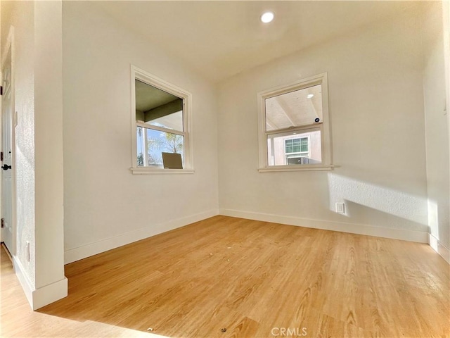 empty room featuring recessed lighting, wood finished floors, and baseboards