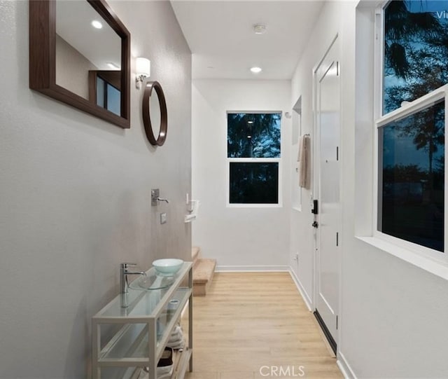 doorway featuring recessed lighting, baseboards, and light wood finished floors