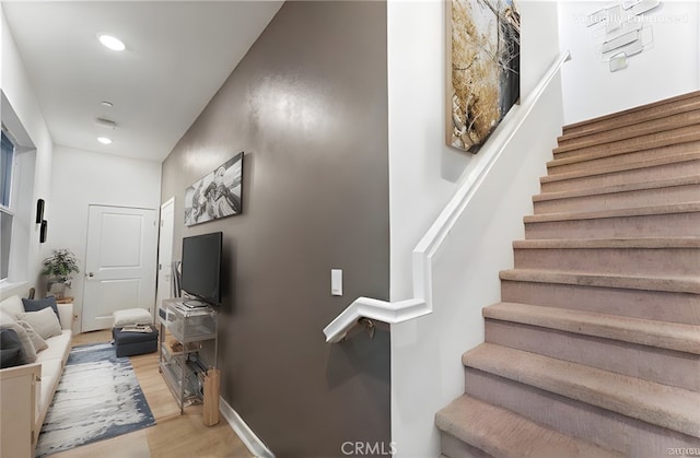 staircase with recessed lighting, baseboards, and wood finished floors