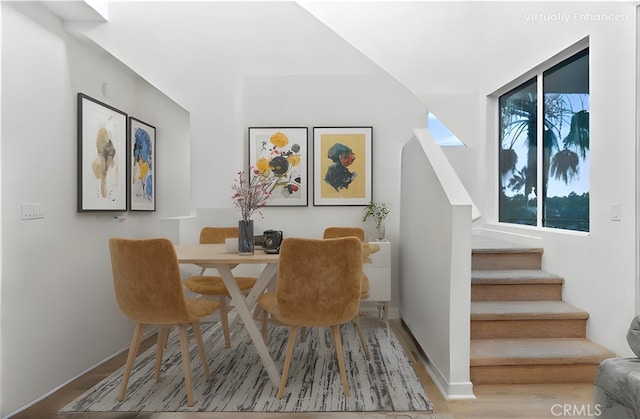 living area with baseboards, wood finished floors, and stairs