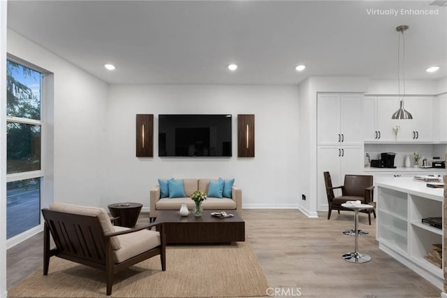 living area featuring recessed lighting, light wood-type flooring, and baseboards