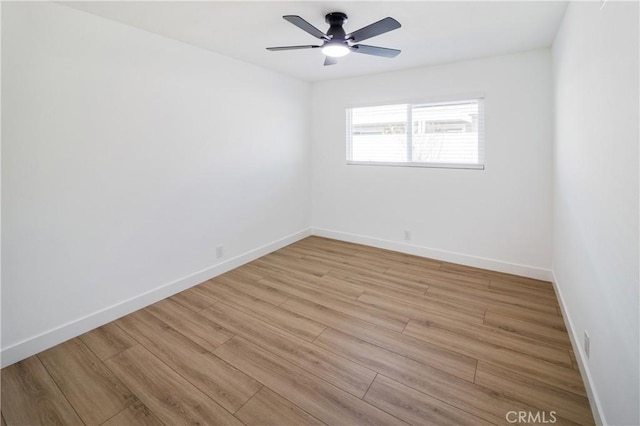 empty room featuring light wood finished floors, ceiling fan, and baseboards