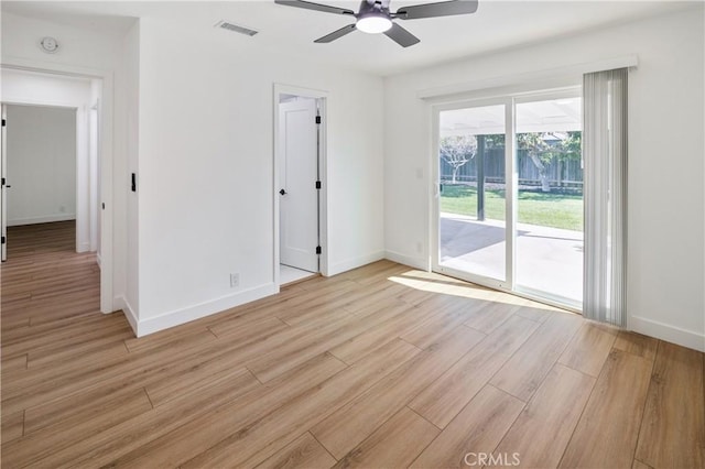 unfurnished room with a ceiling fan, visible vents, light wood-style flooring, and baseboards