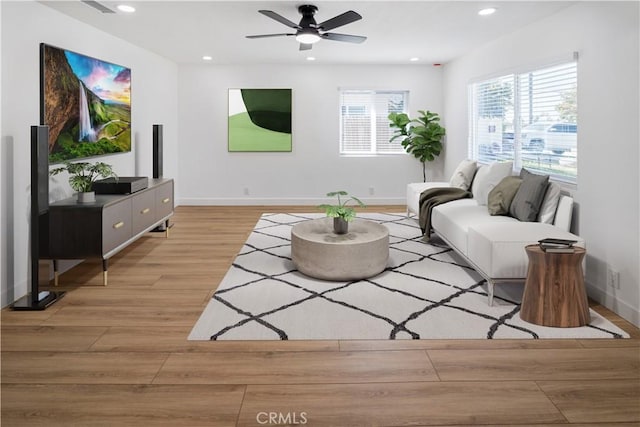 living area with baseboards, ceiling fan, light wood-type flooring, and recessed lighting