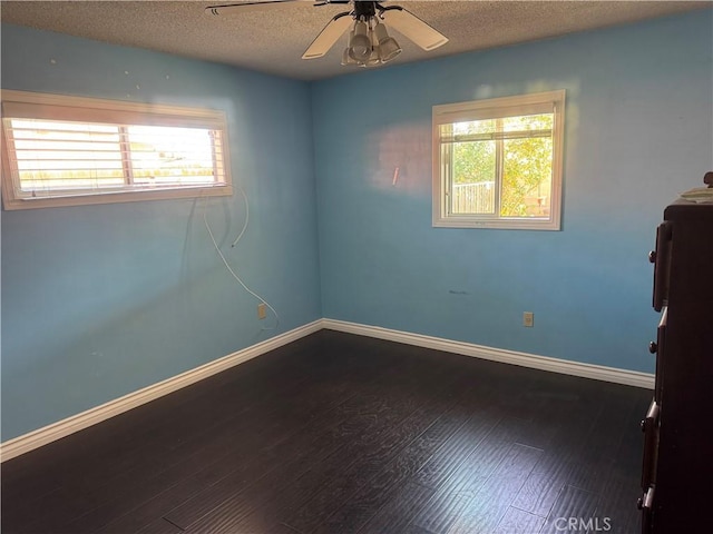 spare room with ceiling fan, baseboards, a textured ceiling, and wood finished floors