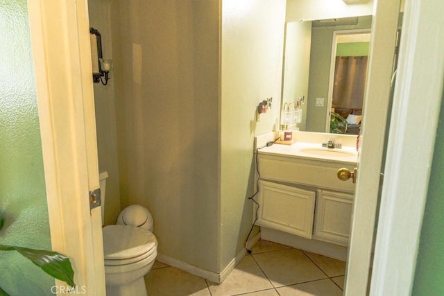 half bathroom featuring tile patterned flooring, baseboards, vanity, and toilet