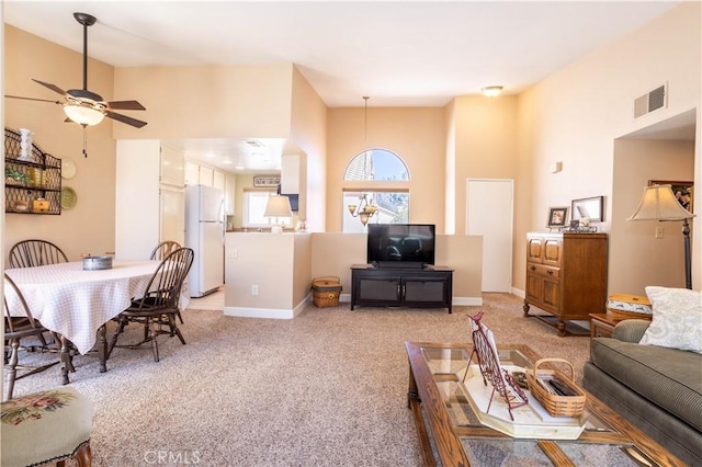 living area with light carpet, a ceiling fan, visible vents, and baseboards