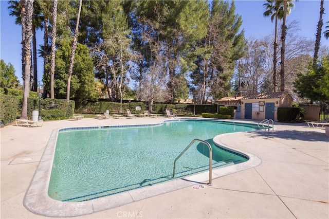 pool with a patio area and fence