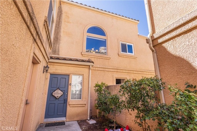 property entrance with stucco siding