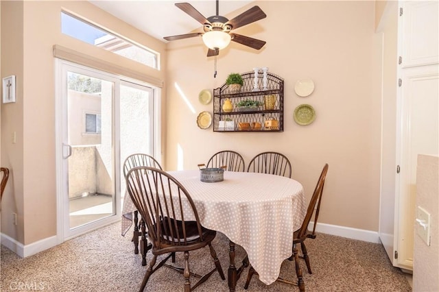 dining room with carpet, a ceiling fan, and baseboards