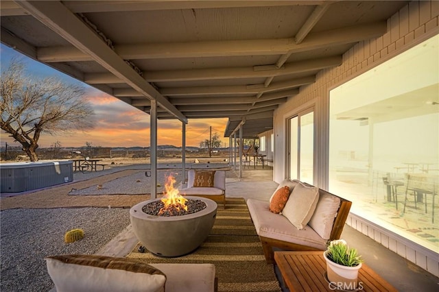 view of patio with an outdoor living space with a fire pit