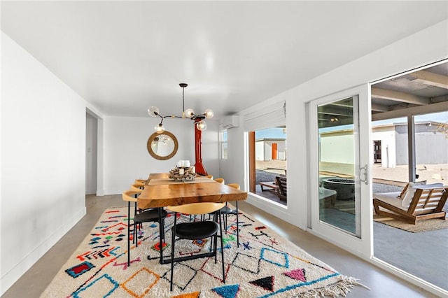 dining space with a notable chandelier, baseboards, concrete flooring, and an AC wall unit