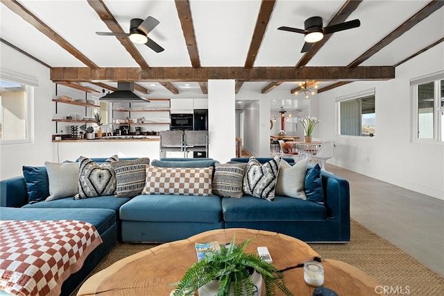 living area with ceiling fan, baseboards, and beam ceiling