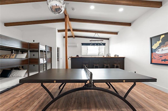 dining room featuring vaulted ceiling with beams, baseboards, wood finished floors, and a wall mounted AC