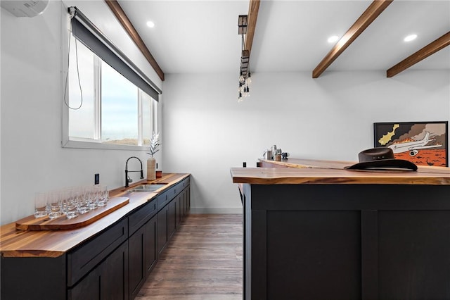 bar with recessed lighting, beamed ceiling, a sink, and wood finished floors