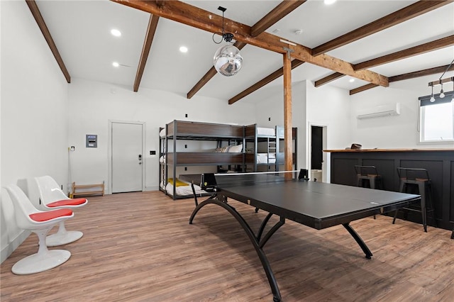 rec room with recessed lighting, beam ceiling, wood finished floors, and an AC wall unit